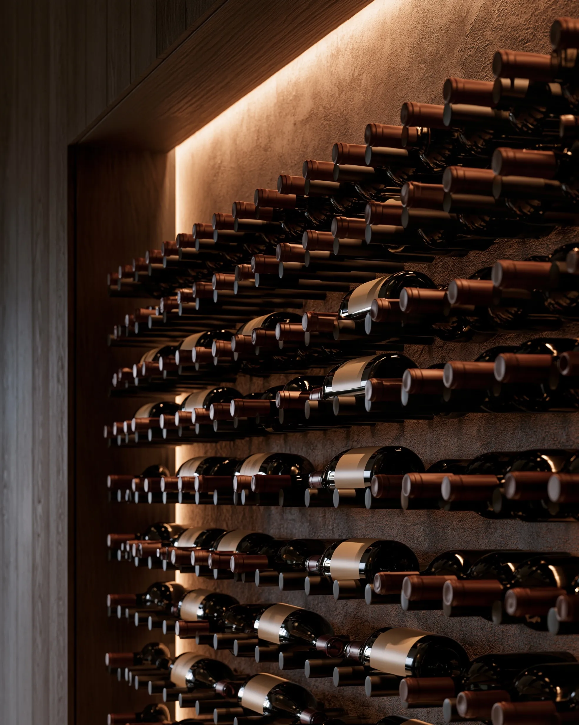 Matte black metal pegs holding wine bottles neck-first in rows against a plaster wall, lit by a hidden warm LED strip