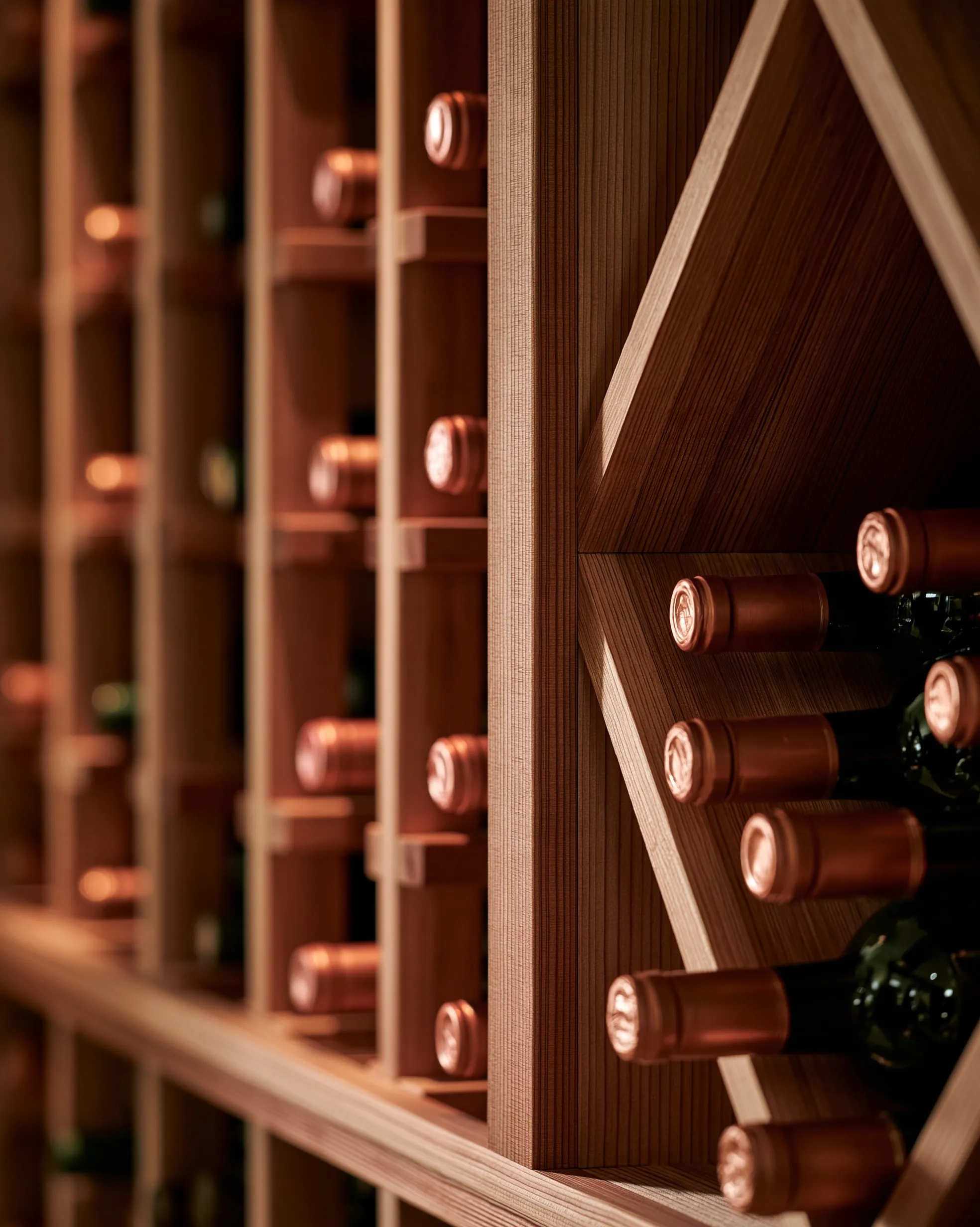 Close view of wood racking with individual bottle slots beside a diamond bin of stacked bottles